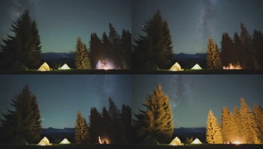 在星星闪烁的夜空下，山间树林中露营地的游客帐篷旁，明亮的篝火旁，徒步旅行者在休息。积极的生活方式和户外生活理念高清在线视频素材下载