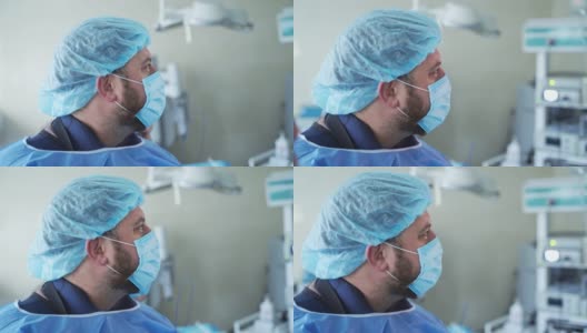 戴着蓝色医用口罩的帅气外科医生。手术手术近景。高清在线视频素材下载