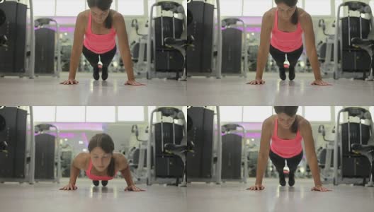 一个年轻女子在健身房做俯卧撑的照片高清在线视频素材下载