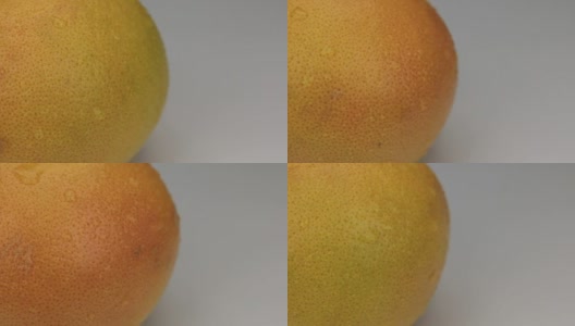 极端特写的橙子葡萄柚的露珠围绕着它的轴旋转高清在线视频素材下载