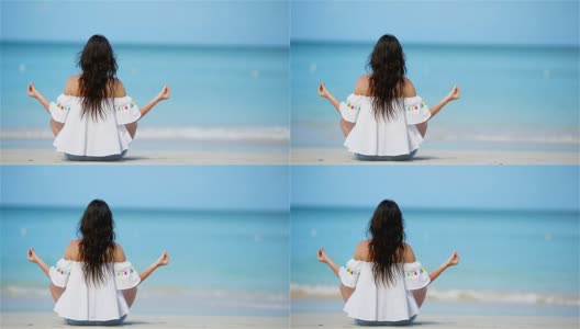美丽的女孩在热带度假瑜伽姿势。健康的年轻女子坐在瑜伽姿势在海滩上沉思高清在线视频素材下载