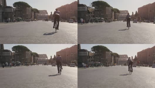 在阳光明媚的日子里，年轻的潮人骑着自行车走向罗马市中心的斗牛场高清在线视频素材下载