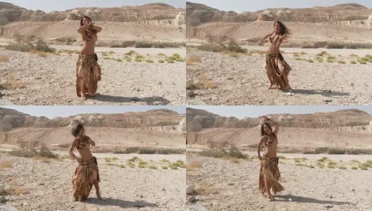 漂亮的女舞者。肚皮舞。沙漠。性感的金棕色连衣裙跳舞。长暴涨。高清在线视频素材下载