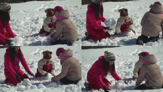 快乐的家庭在冬天的雪山森林里玩耍。妈妈和她的两个孩子扔雪球。做一个雪人。他们笑了。高清在线视频素材下载
