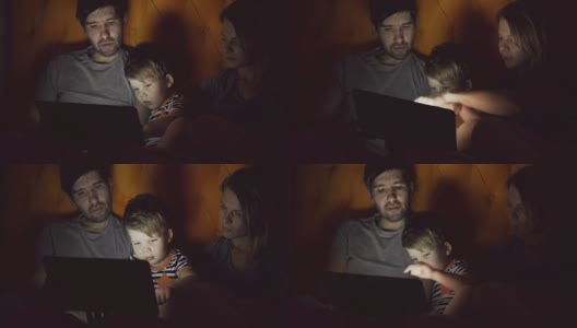 快乐的家庭，小儿子晚上躺在家里的床上学习玩平板电脑高清在线视频素材下载