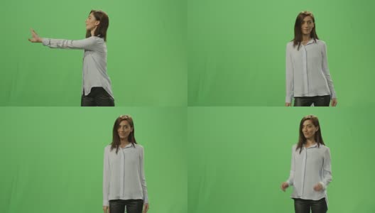 在背景的绿色屏幕上，一名女子正在推动一个虚拟的互动界面。高清在线视频素材下载