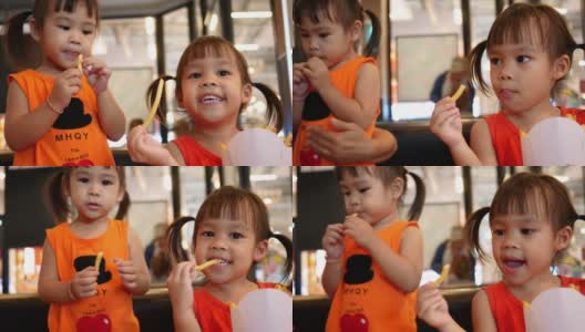 快乐的亚洲小女孩和她的妹妹在餐厅吃薯条。保健和食品理念。高清在线视频素材下载