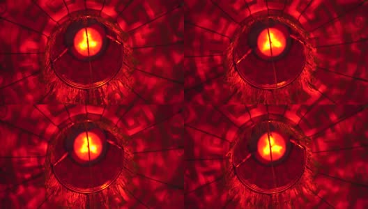 一个红色圆灯笼的特写，里面有一个灯泡，在中国新年庆祝期间的晚上在风中摇摆高清在线视频素材下载