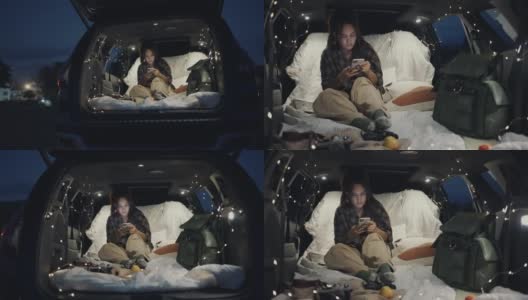 年轻女子晚上在车里露营高清在线视频素材下载