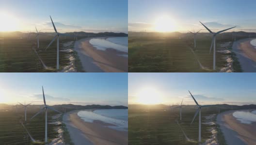 日落时海滩上风力发电场的无人机视角高清在线视频素材下载