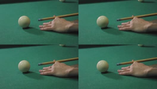 一个男人用一根放在绿色桌子上的球杆打台球的特写镜头高清在线视频素材下载