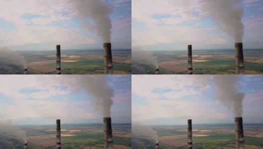 从空中俯瞰高耸的烟囱管和灰色的烟从燃煤电厂。用化石燃料发电高清在线视频素材下载