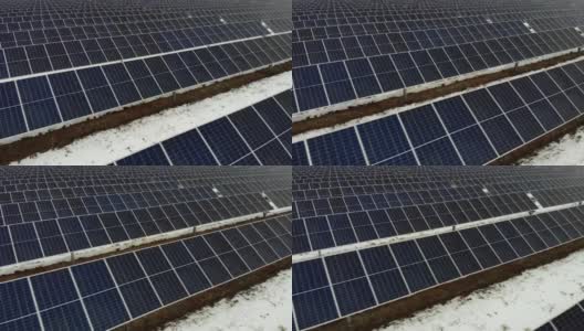 在一个阴天的冬天，数以百计的太阳能电池板排成一排。高清在线视频素材下载