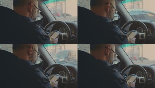 男子戴着口罩坐在车里看着屏幕上的手机短信滚动上网搜索covid新闻高清在线视频素材下载