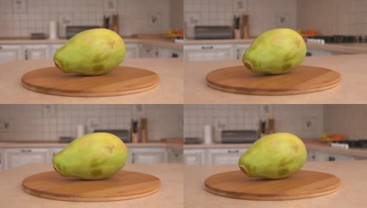 近距离观察整个木瓜果实。以白色厨房为背景的旋转相机。Dolly-shot。高清在线视频素材下载