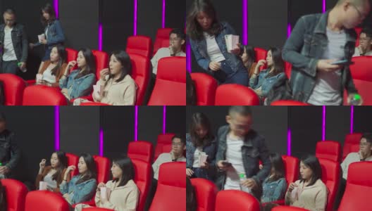 在电影放映时间，一对亚洲中国夫妇进入电影院，试图穿过其他观众到达他们的座位高清在线视频素材下载