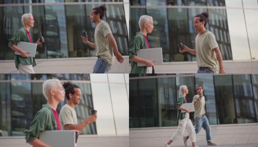 慢动作跟踪拍摄的男人和女人拿着外卖咖啡杯走在街上聊天。夫妻，两个朋友或同事下班后聊天，情绪化的男人表达意见高清在线视频素材下载