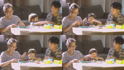 母亲和儿子在家里的客厅里一起玩玩具和玩面团高清在线视频素材下载