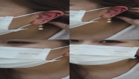 一个十几岁的女孩在美容院做耳洞手术后检查她的耳朵高清在线视频素材下载