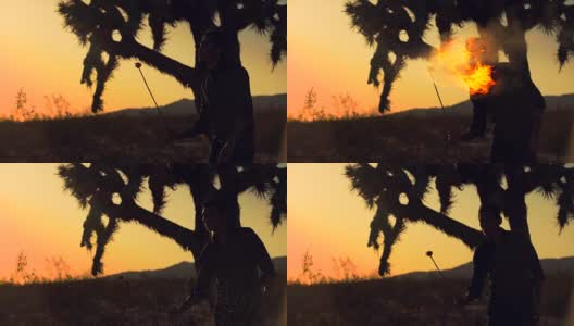 日落时沙漠中吹火的人的剪影高清在线视频素材下载