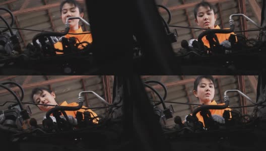 小车低角度视图:亚洲年轻女性汽车技工检查车辆发动机高清在线视频素材下载