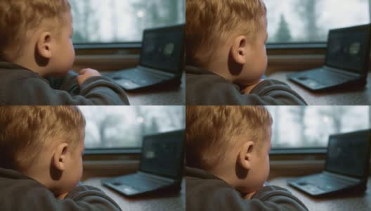 小男孩在火车上用笔记本电脑看视频高清在线视频素材下载
