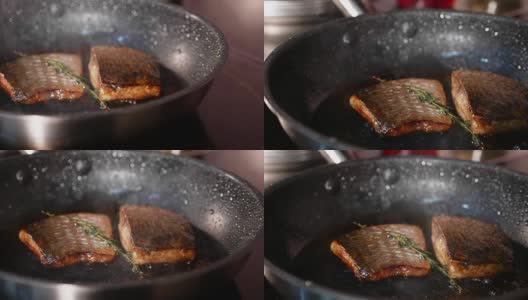 煎鱼，两片罗班鱼片放在热气腾腾的煎锅上。高清在线视频素材下载