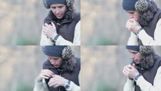 中年妇女在寒冷的冬天在户外搓手的肖像高清在线视频素材下载