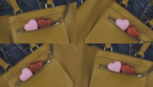 两颗心从一个女性黄色包的口袋里伸出来。旋转。爱情与时尚的背景。高清在线视频素材下载