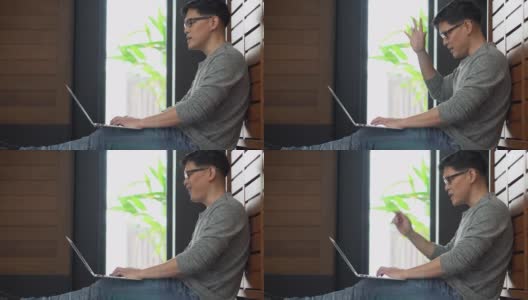 新冠肺炎疫情期间，亚洲年轻商人利用笔记本电脑召开视频会议，与居家隔离的同事进行在线工作交流高清在线视频素材下载