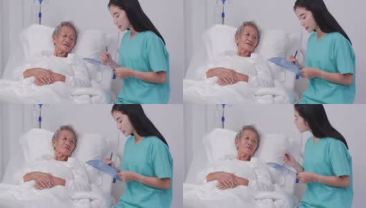 女医生坐在写字板上写着信息，一位老妇病人躺在病床上。高清在线视频素材下载