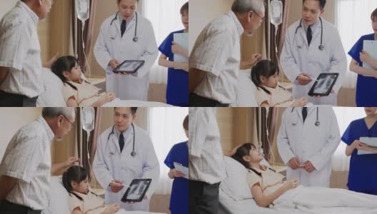 亚洲友好的医生男子与父母交谈，并显示x光结果平板电脑在病房。儿童医院儿科病房。医生跟进病情病人。高清在线视频素材下载