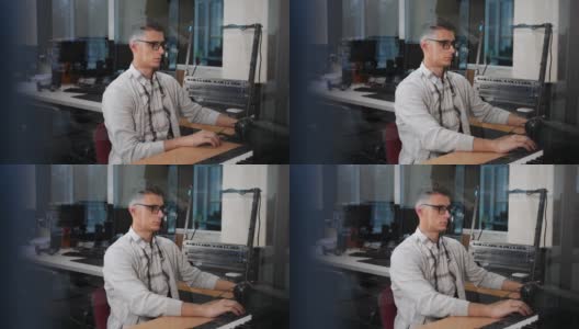 一个戴眼镜的年轻人在他办公室的电脑前工作高清在线视频素材下载
