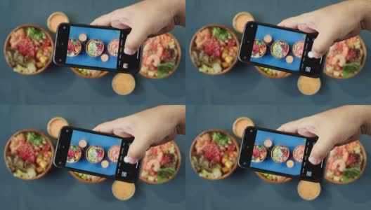 用智能手机俯视图拍摄夏威夷poke碗。由切成片的蔬菜、海鲜和绿叶植物制成的熟戳。健康的素食。亚洲素食生食，筷子高清在线视频素材下载
