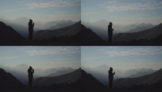 一个孤独的女性徒步旅行者在山顶喝咖啡高清在线视频素材下载
