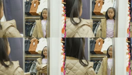 亚洲女孩有乐趣试穿布在镜子前高清在线视频素材下载