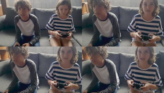 11 -12岁的小男孩和小女孩用手持控制器玩电子游戏高清在线视频素材下载