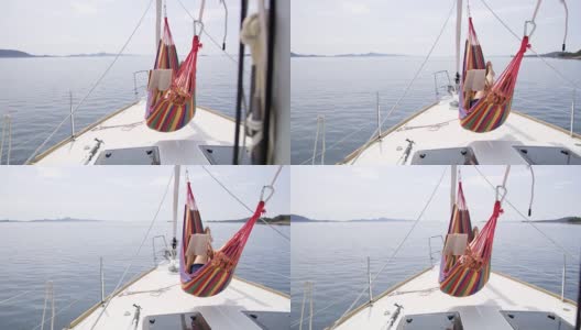 一个女人在帆船上的吊床上看书高清在线视频素材下载