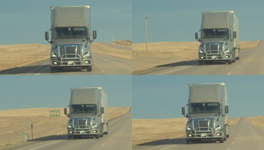 在阳光明媚的日子里，在乡村公路上行驶的半卡车的正面视图高清在线视频素材下载