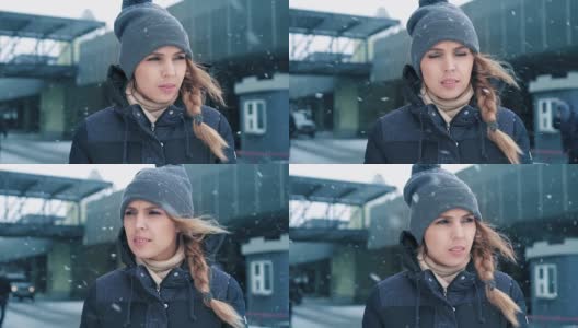 肖像镜头美丽的女人站在户外在冬天和看雪。缓慢的莫高清在线视频素材下载
