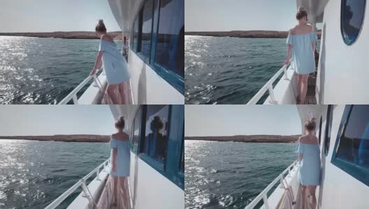 一个年轻美丽的白人女人在游艇上的肖像在蓝色的裙子和太阳镜邀请旅行。假期的概念，自由，阳光夏日。背景是蓝色的海洋。steadycam高清在线视频素材下载