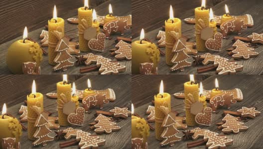 圣诞节自制的姜饼曲奇放在木桌上。由天然蜂蜡制成的黄色香味蜡烛。高清在线视频素材下载