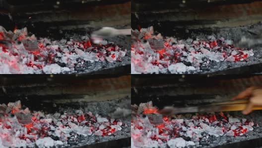 用火钳从火中取出木炭的人的手高清在线视频素材下载