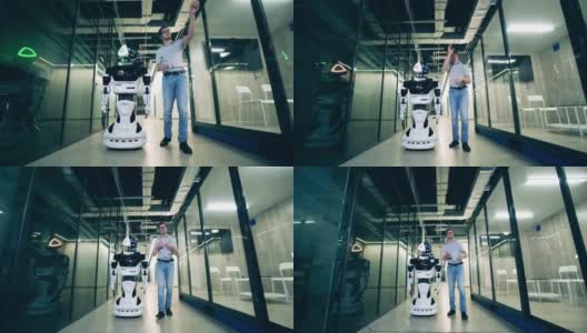 一位男专家正在向一个机器人展示一个商务大厅。人与机器人通信概念。高清在线视频素材下载
