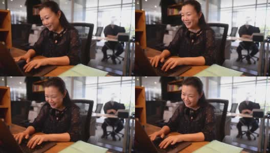 两名员工在开放式办公室工作，使用科技交流打字和微笑的高清高清在线视频素材下载