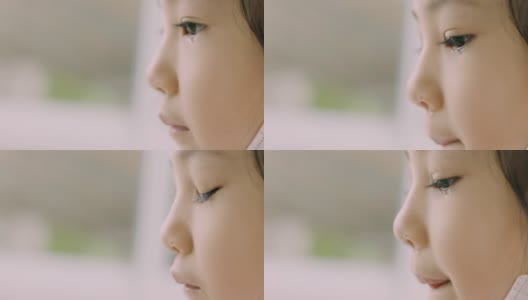 可爱的亚洲小女孩的临场临场侧视在哭泣，通过她的眼睛和美丽的肤色来表达人们的悲伤、不快乐、沮丧和悲伤。高清在线视频素材下载