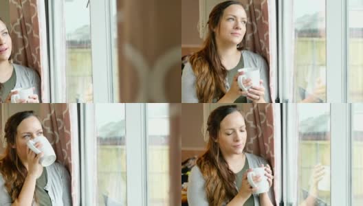 年轻漂亮的白人女人一边喝着咖啡一边凝视着窗外高清在线视频素材下载