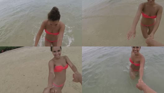 年轻女子牵着男子的手在海滩上走水边幸福的微笑动作海边幸福夫妇的视点高清在线视频素材下载