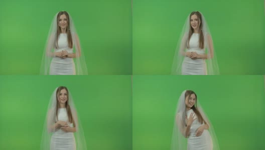 年轻的白人女孩穿着新娘礼服，在绿色的背景上。高清在线视频素材下载