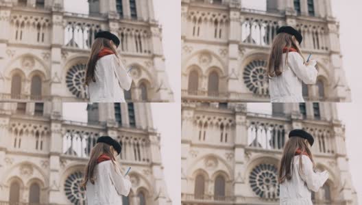 小艺术家贝雷帽在巴黎圣母院附近，法国。时髦女孩在著名的教堂附近做她的爱好高清在线视频素材下载